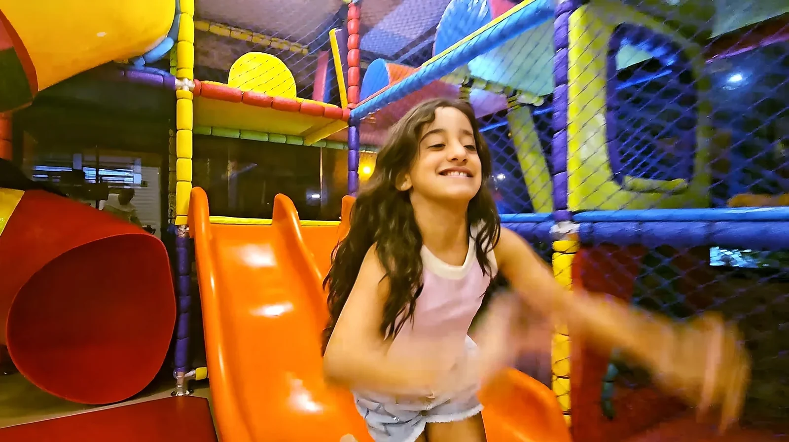 Menina se diverte no escorregador do Espaço Kids