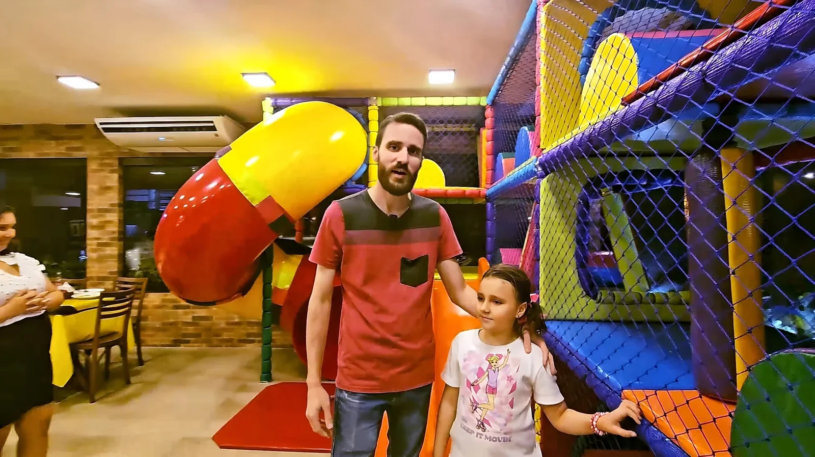 Família junto à área de brinquedos do restaurante